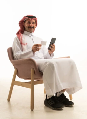 رجل سعودي يستخدم هاتف ذكي وبطاقة ائتمان في استوديو