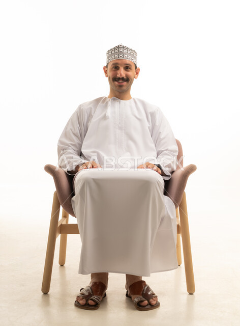 An Omani Arab Gulf man wearing a kumma and a dishdasha is sitting on a chair with various gestures and movements, against a white background.