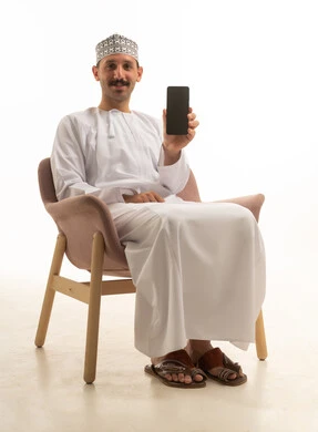 Saudi Man with Smartphone Sitting on Chair