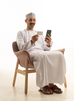 Saudi Man Using Smartphone and Credit Card in Studio