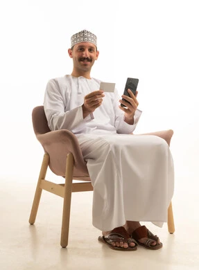 Omani Man Using Credit Card and Smartphone