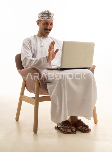 رجل سعودي بالزي التقليدي في مكالمة فيديو عبر المحمول