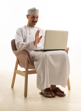 Saudi Man in Traditional Dress on Laptop Video Call
