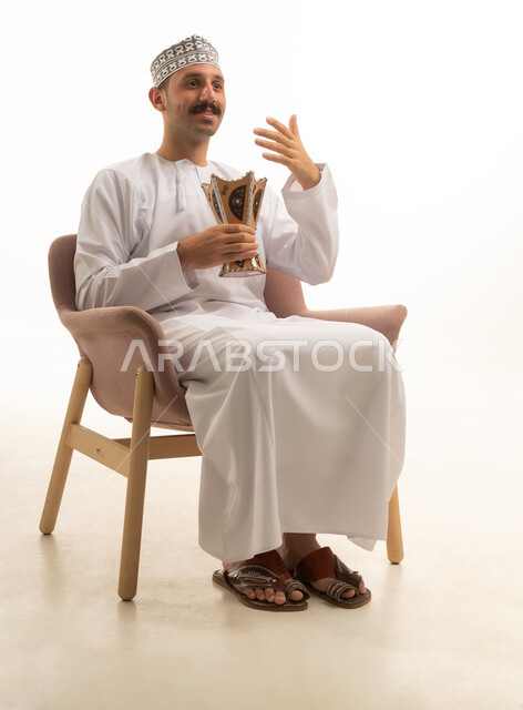 رجل عماني يحمل مبخرة تقليدية في استوديو