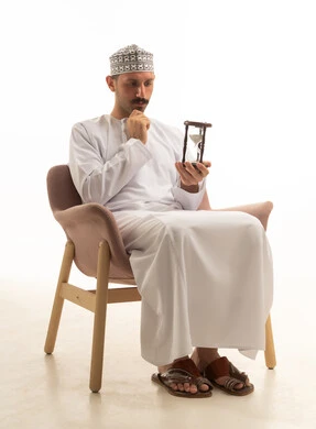 Omani Man in Traditional Dress Holding Hourglass