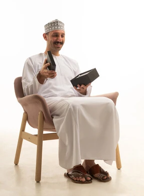 Saudi Man Opening Gift Box in Studio on White Background