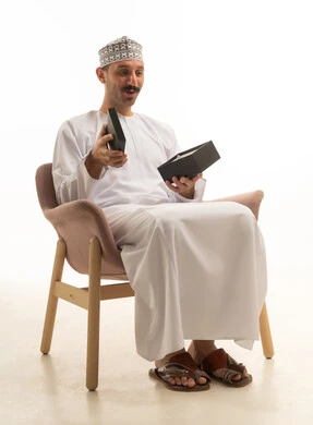 رجل سعودي بالزي التقليدي يفتح صندوق هدايا