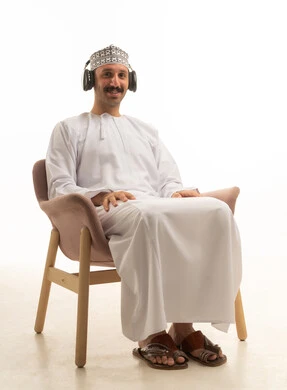 رجل عماني يرتدي سماعات بالزي التقليدي