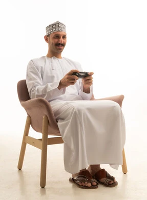 رجل سعودي يلعب ألعاب الفيديو في الاستوديو بخلفية بيضاء