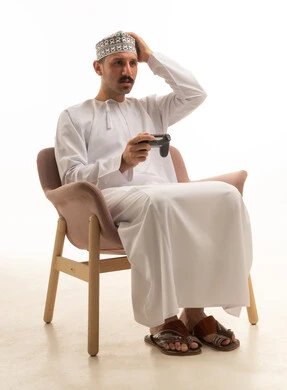 رجل سعودي يلعب ألعاب الفيديو بخلفية بيضاء