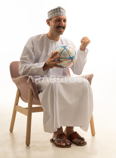 رجل عماني يحتفل بكرة القدم بخلفية بيضاء