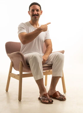 Saudi Man Sitting in Armchair and Pointing in Studio