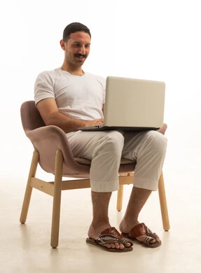 Saudi Man Using Laptop in Armchair White Background