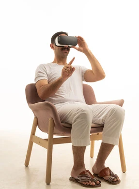 رجل سعودي يستخدم نظارة الواقع الافتراضي جالسًا