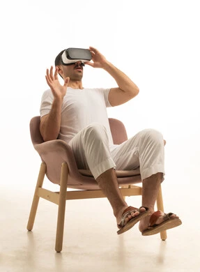 Saudi Man Using VR Headset in Studio Armchair
