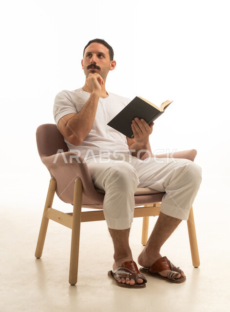 Saudi Man Reading Book and Thinking in Studio