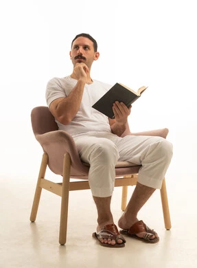 رجل سعودي يقرأ كتاباً ويتأمل في الاستوديو