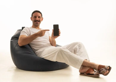 Saudi Man Pointing at Smartphone Screen on Blue Beanbag