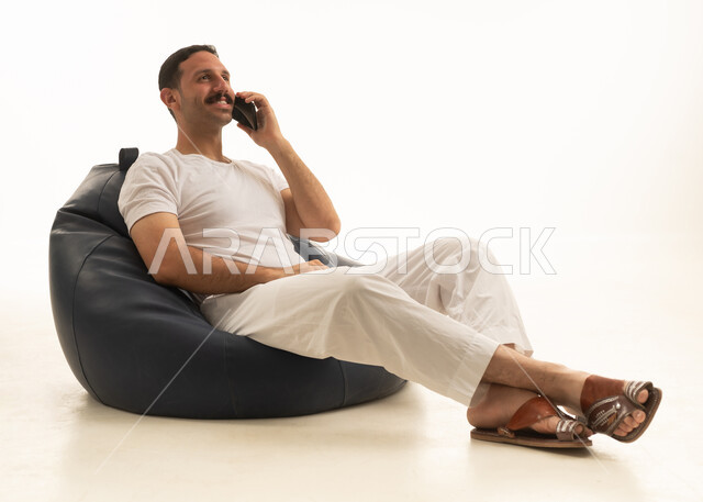Saudi Man Talking on Smartphone on Bean Bag Chair