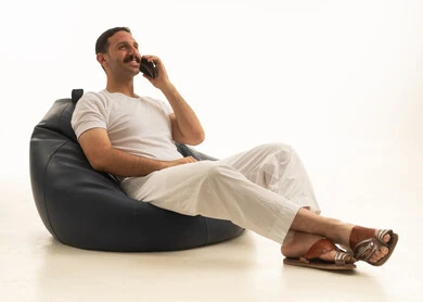 رجل سعودي يتحدث بالهاتف على كرسي بين باج