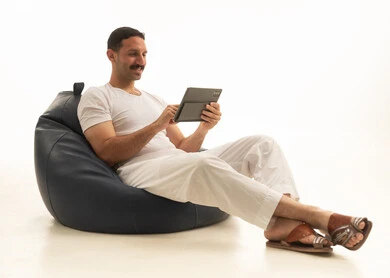 رجل سعودي يستخدم جهاز لوحي على كرسي مريح