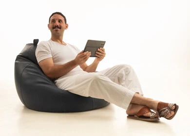 Saudi Man on Beanbag Using Digital Tablet in Studio