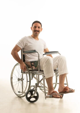 Smiling Saudi Man in Wheelchair on White Background