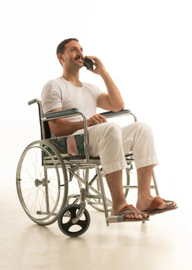 Saudi Man in Wheelchair Using Mobile Phone