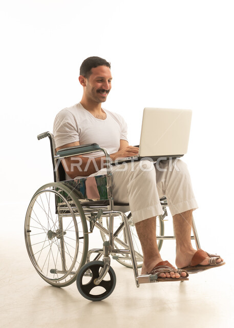 رجل سعودي من ذوي الهمم يستخدم المحمول على كرسي متحرك