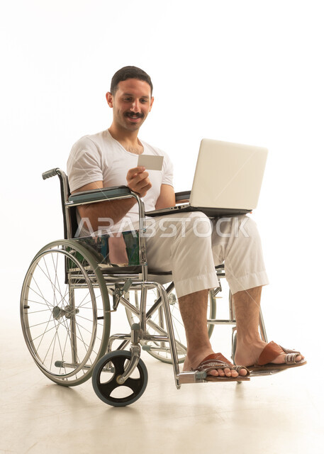 Saudi Man in Wheelchair Online Shopping with Laptop