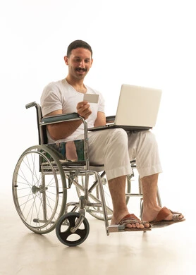 Saudi Man in Wheelchair Online Shopping with Laptop