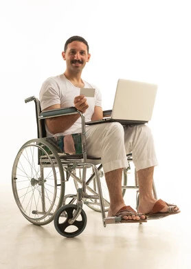 رجل سعودي على كرسي متحرك يستخدم المحمول والبطاقة