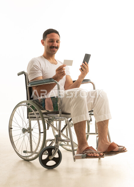 رجل سعودي على كرسي متحرك يقوم بالدفع الإلكتروني