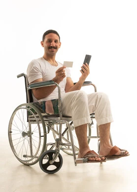 Saudi Man in Wheelchair Using Smartphone and Credit Card
