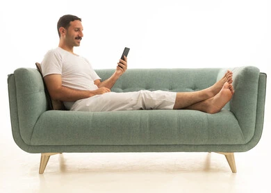 Saudi Arab Man Using Smartphone on Green Sofa