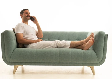 رجل سعودي يتحدث بالهاتف على أريكة حديثة