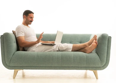 Saudi Man on Sofa Using Laptop for Video Call