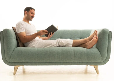 رجل سعودي يقرأ كتاباً على أريكة حديثة