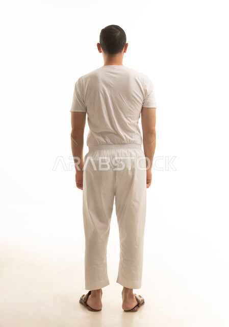 رجل سعودي يقف بظهره بملابس داخلية بيضاء