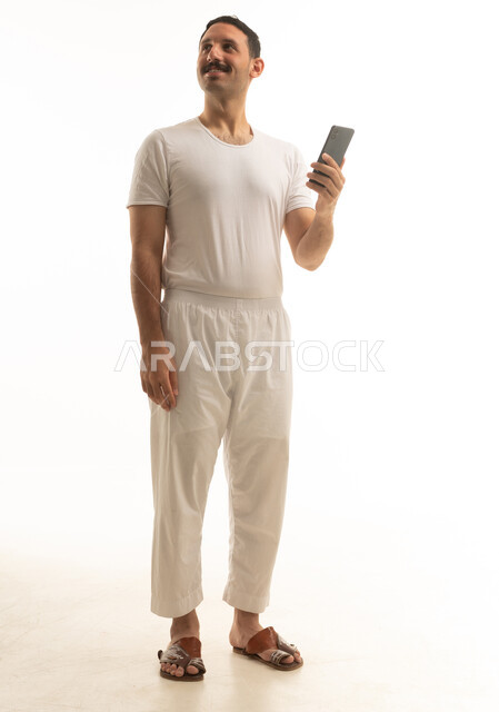 رجل سعودي مع هاتف ذكي على خلفية بيضاء