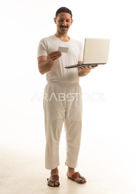 Saudi Man Using Laptop and Credit Card on White Background