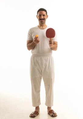 رجل سعودي يمسك بمضرب تنس طاولة على خلفية بيضاء