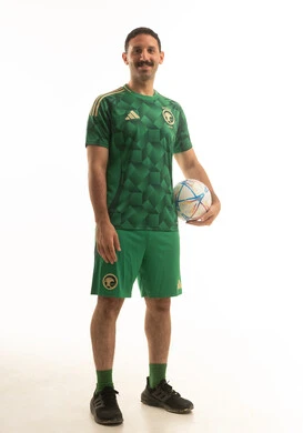 A Saudi football player wearing a green sports outfit is holding a football in his hand, with various gestures and movements, full body, white background.