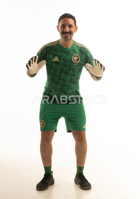 حارس مرمى سعودي بالزي الأخضر أمام خلفية بيضاء