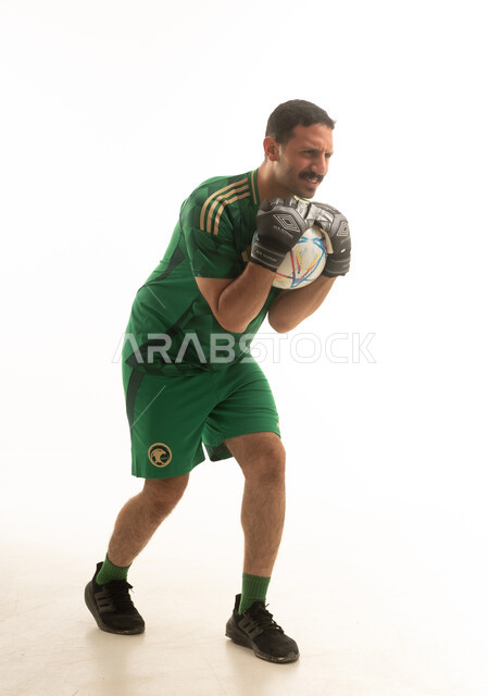 لاعب كرة قدم سعودي يرتدي الزي الرياضي الاخضر يمسك بيده كرة قدم , ايماءات وحركات متنوعه, كامل الجسم, خلفيه بيضاء