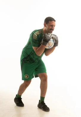 لاعب كرة قدم سعودي يرتدي الزي الرياضي الاخضر يمسك بيده كرة قدم , ايماءات وحركات متنوعه, كامل الجسم, خلفيه بيضاء