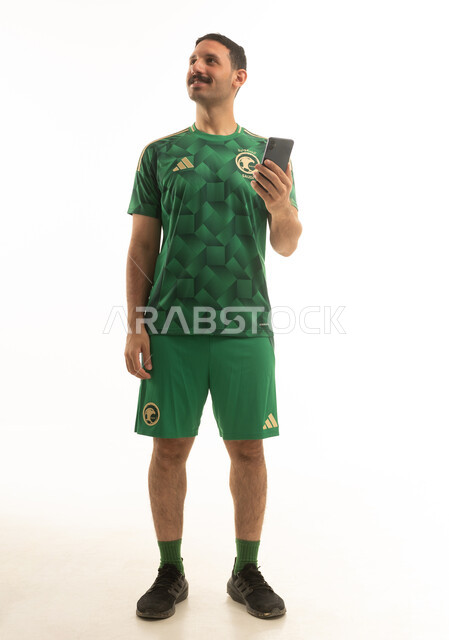 Saudi Man in National Football Team Jersey with Phone