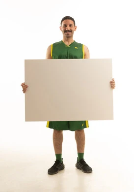 رياضي سعودي يحمل لوحة بيضاء فارغة في الاستوديو