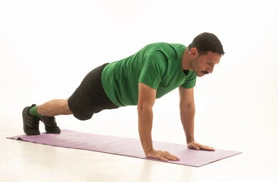 رجل سعودي يؤدي تمرين البلانك على سجادة يوجا