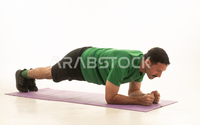 Saudi Man Doing Plank Exercise on White Background